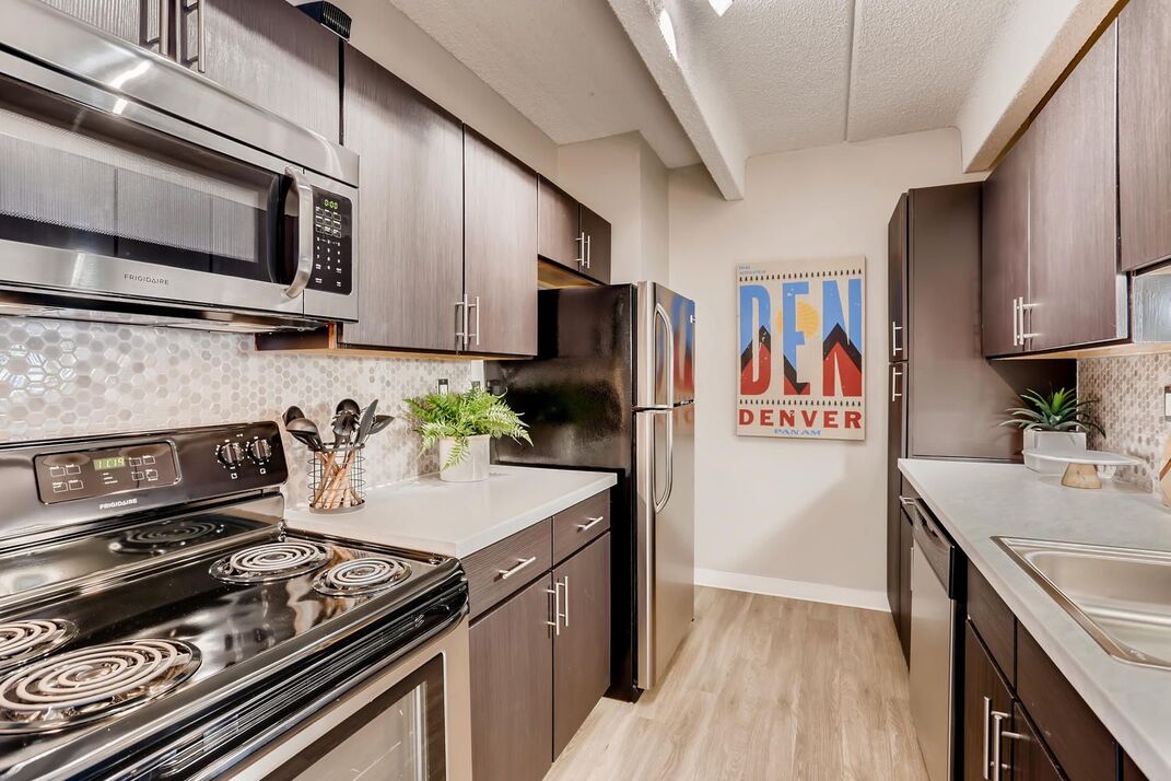 kitchen with steel appliances and picture on the wall that says Denver