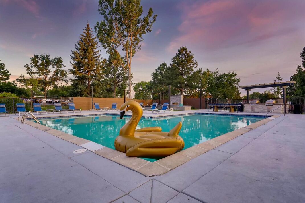 pool view with tiki lights and blue lounge chairs and floating pool toy