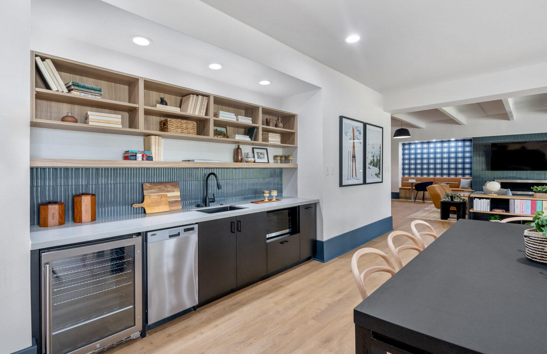 indoor community space with dining table and chairs next to kitchenette